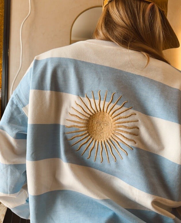 BUZO RAYADO CELESTE SOL BORDADO ESPALDA